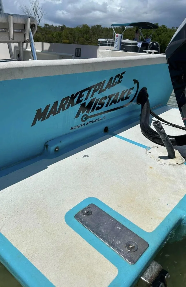 Boat named Marketplace Mistake, Bonita Springs FL, in bold black vinyl lettering