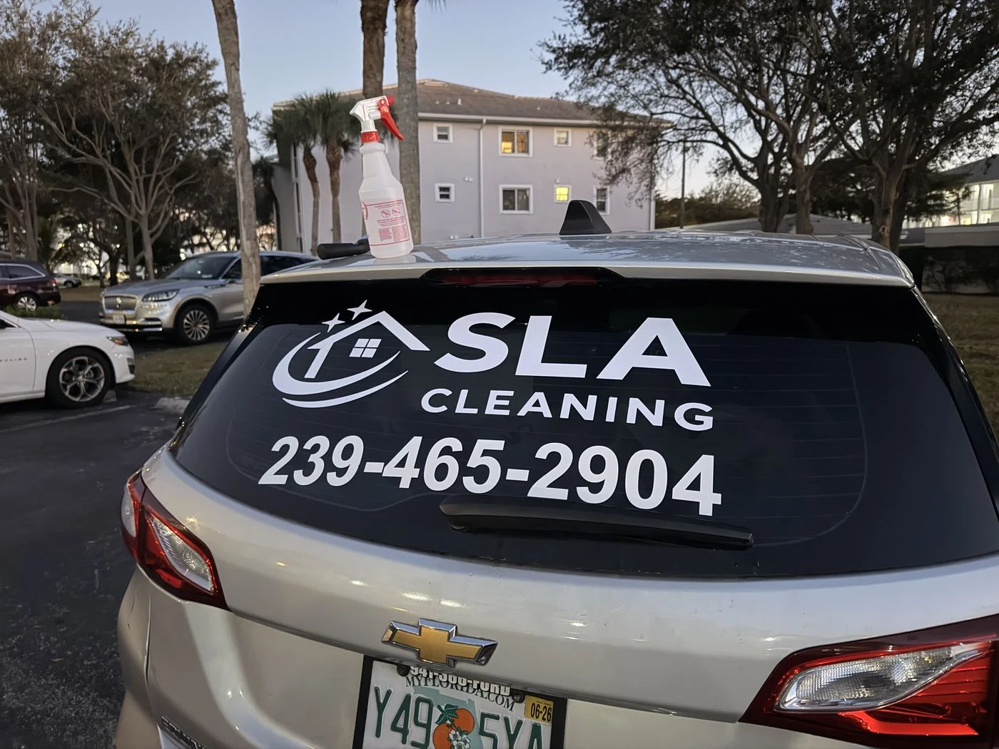 Rear window lettering for SLA Cleaning showing logo, business name, and phone number 239-465-2904